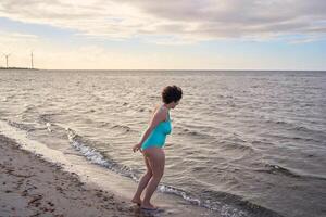 a young plus-size woman is engaged in winter swimming and warming up by the sea photo