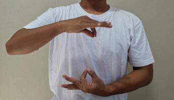 Young man learning and communicating in american sign language photo