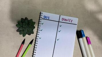 Concept of Do's or Don'ts write on book isolated on Wooden Table. photo