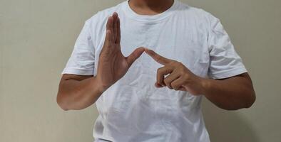 Young man shows sign language to talk. Hand gestures of people with hearing impairment photo