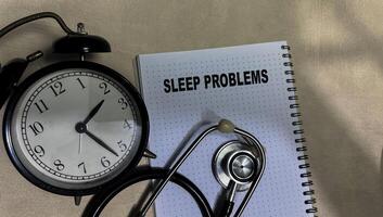Concept of Sleep Problems write on book isolated on Wooden Table. photo