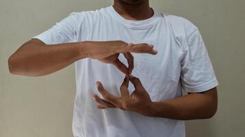 Young man learning and communicating in american sign language photo