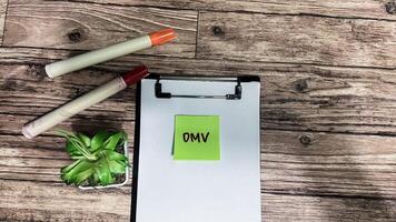 Concept of DMV - Dynamic Management Views write on sticky notes isolated on Wooden Table. photo