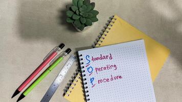 Concept of SOP - Standard Operating Procedure write on book isolated on Wooden Table. photo