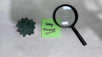 Concept of Stay Focused write on sticky notes isolated on Wooden Table. photo