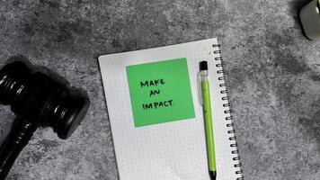 Concept of Make an Impact write on sticky notes isolated on Wooden Table. photo