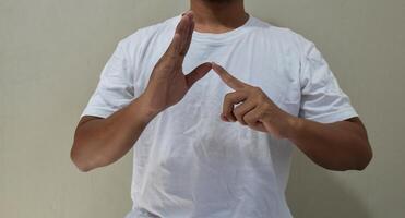 Young man shows sign language to talk. Hand gestures of people with hearing impairment photo