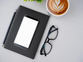 Top view of mock up modern workspace with blank screen smartphone, keyboard. Office situation with keyboard and accessories isolated on white. Copy space, Flat lay. photo