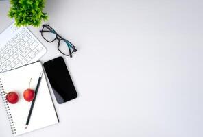 Top view of mock up modern workspace with blank screen smartphone, keyboard. Office situation with keyboard and accessories isolated on white. Copy space, Flat lay. photo