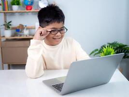Asian boy student using computer laptop learning. Educational of tech concept, Staying at home, Presenting a modern educational way of life. Virtual internet online class from school teacher. photo