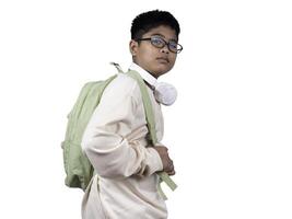Portrait of boy in casual clothes carry a green bag and white headphones isolated on a white background, The concept of education and way of life. Cute boy posing in casual clothes with clipping part. photo