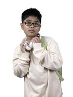 Portrait of boy in casual clothes carry a green bag and white headphones isolated on a white background, The concept of education and way of life. Cute boy posing in casual clothes with clipping part. photo
