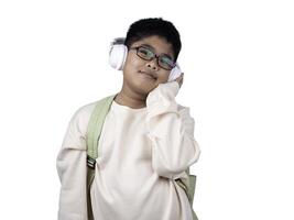 Portrait of boy in casual clothes carry a green bag and white headphones isolated on a white background, The concept of education and way of life. Cute boy posing in casual clothes with clipping part. photo