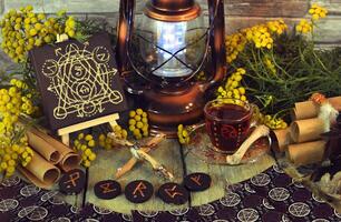Mystic still life with tarot cards, lantern and witchy ritual objects on old altar table. Occult, esoteric, wicca, Halloween and gothic concept. No foreign language, all symbols are fictional photo
