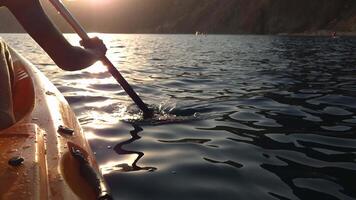Kayaking Paddle Sunset Water - A woman paddling a kayak with a red paddle on a lake at sunset. video