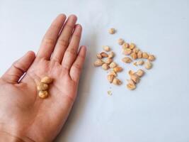 roasted peanuts on palm isolate on white photo