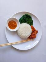 rice with padang rendang chicken side dish and cassava leaf vegetables on a white plate isolate on white photo