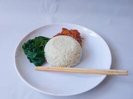rice with padang rendang chicken side dish and cassava leaf vegetables on a white plate isolate on white photo