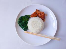 rice with padang rendang chicken side dish and cassava leaf vegetables on a white plate isolate on white photo