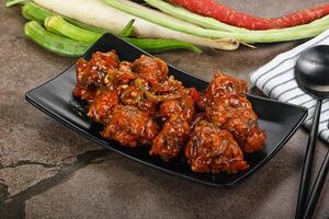 Manchurian chicken with sauce and spices photo