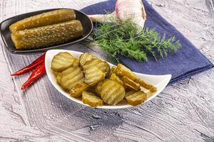 Sliced marinated cucumbers in the bowl photo