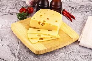 Maasdam cheese piece with slices photo
