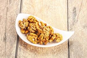 Cracked unshelled walnut in the bowl photo