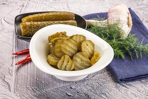 Sliced marinated cucumbers in the bowl photo