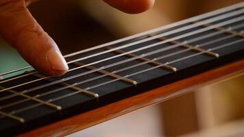 Playing the strings of a guitar, close up video