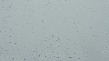 Drops of rain in the glass of a window sliding a raining day video