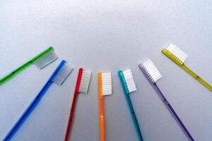 Colorful tooth brushes lay around tooth floss in tooth toy shape. Dentistry concept photo