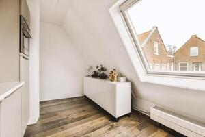 A small room with a window and a white cabinet photo