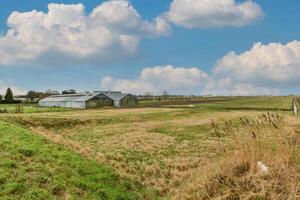 A field with a barn and a field with a field photo