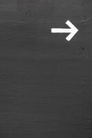 A white arrow on a gray wall with space for text photo