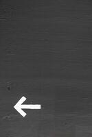 A white arrow on a gray wall with space for text photo