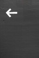 A white arrow on a gray wall with space for text photo