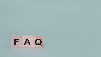 Wooden block with word the FAQ. The concept of question or answer time. photo