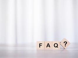 Wooden block with word the FAQ with question marks. The concept of question or answer time. photo