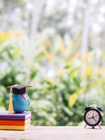 Student creative desktop, earth globe with graduation hat on hardcover book and black alarm clock. Copy space for text, Back to school, Education concept photo
