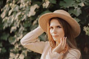 Woman with straw hat stands in front of vineyard. She is wearing a light dress and posing for a photo. Travel concept to different countries photo