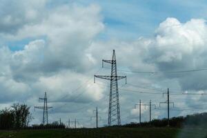 High voltage towers with sky background. Power line support with wires for electricity transmission. High voltage grid tower with wire cable at distribution station. Energy industry, energy saving photo
