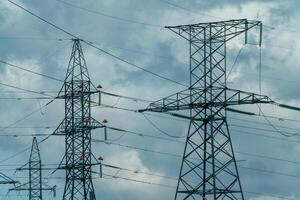 High voltage towers with sky background. Power line support with wires for electricity transmission. High voltage grid tower with wire cable at distribution station. Energy industry, energy saving photo