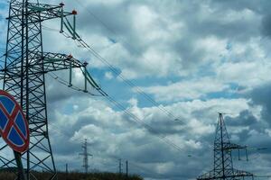 High voltage towers with sky background. Power line support with wires for electricity transmission. High voltage grid tower with wire cable at distribution station. Energy industry, energy saving photo