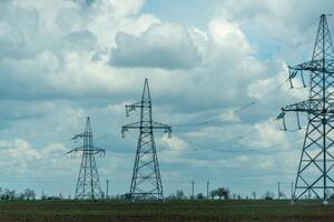 High voltage towers with sky background. Power line support with wires for electricity transmission. High voltage grid tower with wire cable at distribution station. Energy industry, energy saving photo
