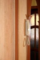 The intercom handset hangs in profile in the reflection of a mirror photo