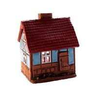 Ceramic candlestick in the form of a house with glowing windows from a candle inside - color photo, isolate for design photo