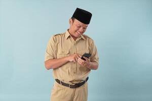 Cheerful government worker man wearing khaki uniform using smartphone to browse internet. photo