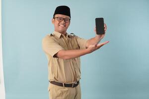 Smiling government worker man wearing khaki uniform presenting copy space on smartphone. photo
