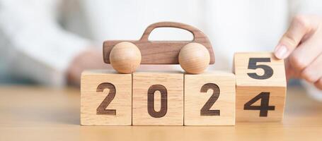 2024 end year to Happy New Year 2025 with Car model on table. Automobile Tax, Car Insurance, Financial, vehicle Repair and Maintenance and New Year concept photo