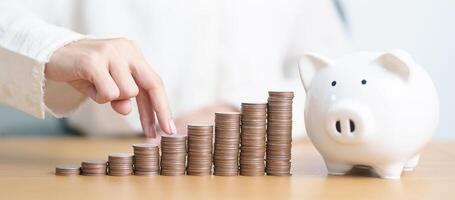 Money Saving for Future Plan, Retirement fund, Pension, Investment, Wealth, Salary and Financial concepts. hand step up coin with piggy bank on table, Money Counting and stack arrangement for Growth photo